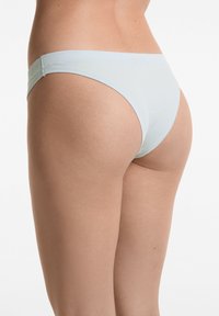 Ljusblå ribbade kalsonger med smal midjeband, sömlösa sidor och en åtsittande passform. Mjuk textur med subtil glans, designad för komfort.