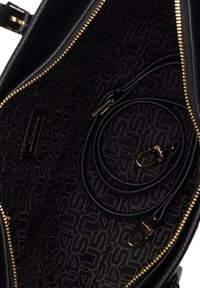 Borsa a tracolla nera in pelle con una superficie testurizzata. L'interno presenta una fodera in tessuto a motivi in tonalità scure, hardware dorato e una tracolla rimovibile.