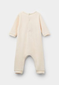 Combi-short pour bébé de couleur crème avec des manches longues, un col rond et une fermeture à boutons au dos. Texture douce, poignets élastiques et ouvertures de jambe arrondies.