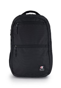 Zaino nero realizzato in tessuto testurizzato. Presenta due tasche anteriori con zip e una maniglia superiore. Include un patch con logo nella parte inferiore anteriore.