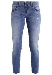Blaue Jeans aus Denim mit Slim Fit, mit abgewetzten Stellen und Verfärbungen. Vier Taschen, ein goldener Knopfverschluss mit Reißverschluss.