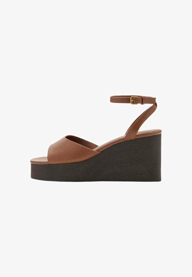 Sandale compensée en cuir marron avec bout ouvert, semelle plateforme noire épaisse et bride cheville avec boucle dorée.