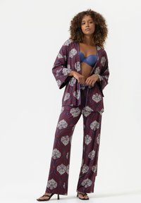 Pyjama set in diep bordeaux met bloemenpatronen. Inclusief een kimono-stijl top en brede broekspijpen, gemaakt van gladde stof. Bevat blauwe onderkleding.