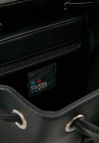 Czarna skórzana torba typu bucket z materiałową podszewką, ozdobiona srebrnymi elementami i wewnętrzną kieszenią z metką marki "even & odd".