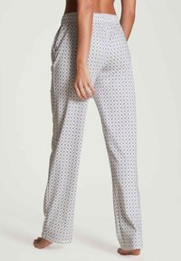 Dames pyjamabroeken van lichte stof, met een herhalend geometrisch patroon in paars en blauw, met een ontspannen pasvorm en zijzakken.