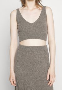 Top corto a maglia marrone con scollo a V e spalline larghe, realizzato in una morbida miscela di lana, con un design aderente che arriva alla vita.