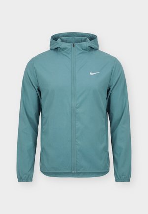 Világoskék kapucnis Nike dzseki teljes elülső cipzárral, elasztikus mandzsettákkal és kontrasztos fehér Nike swoosh logóval a mellrészen.