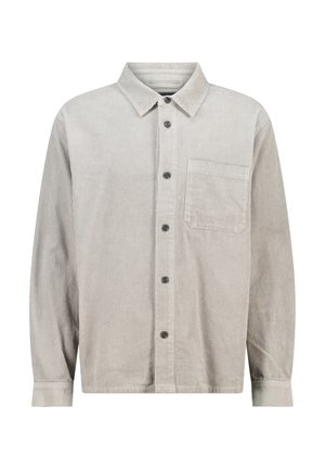 Chemise en velours côtelé gris clair avec un col boutonné, une poche frontale et des boutons noirs. Présente une texture à côtes verticales et des manches longues.