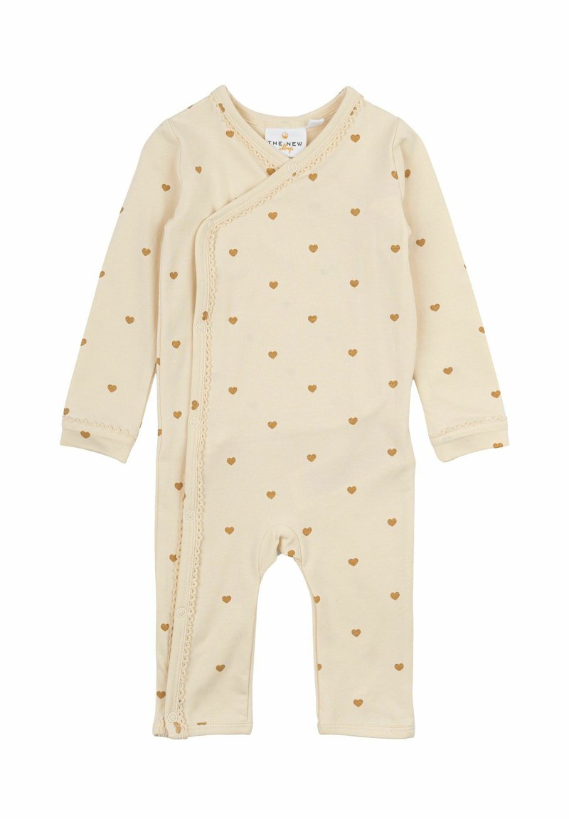 Beige bomullsoverall för baby med hjärtformade mönster, lång ärm, innesluten design, spetsdetaljer och knappar längs sidan för enkel påklädning.