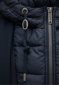 Marinejacke mit gestepptem Muster, ausgestattet mit einem Reißverschluss und einer geflochtenen Kordelzugakzent mit metallischem Stopper.