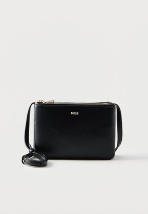 Zwarte leren crossbodytas met gouden ritssluiting en verstelbare schouderband, met het woord "BOSS" in gouden letters aan de voorkant.
