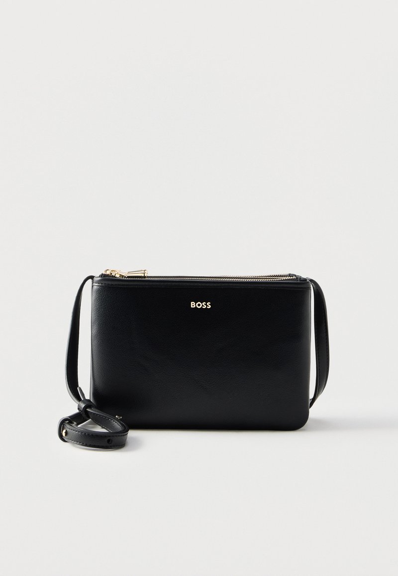Μαύρο δερμάτινο τσαντάκι crossbody με χρυστό φερμουάρ και ρυθμιζόμενο λουράκι, με τη λέξη «BOSS» σε χρυσά γράμματα μπροστά.