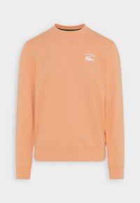 Felpa arancione in morbido cotone, con collo rotondo, maniche lunghe e logo Lacoste bianco sul petto.