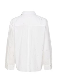 Camisa blanca de botones con mangas largas, que presenta un pliegue central en la espalda y adornos metálicos dispersos. Textura de tela suave.