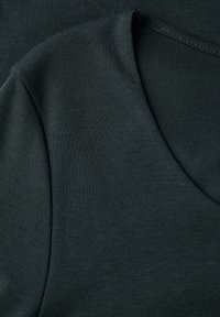 Schwarzer Baumwoll-T-Shirt-Stoff mit rundem Ausschnitt. Glatte Textur mit einem dezenten Glanz, in einfarbigem Design und ohne sichtbare Muster.