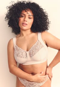 Sutien beige deschis cu panouri din dantelă florală și bretele late, realizat dintr-un material neted, cu cusături și slip bikini asortat din dantelă.