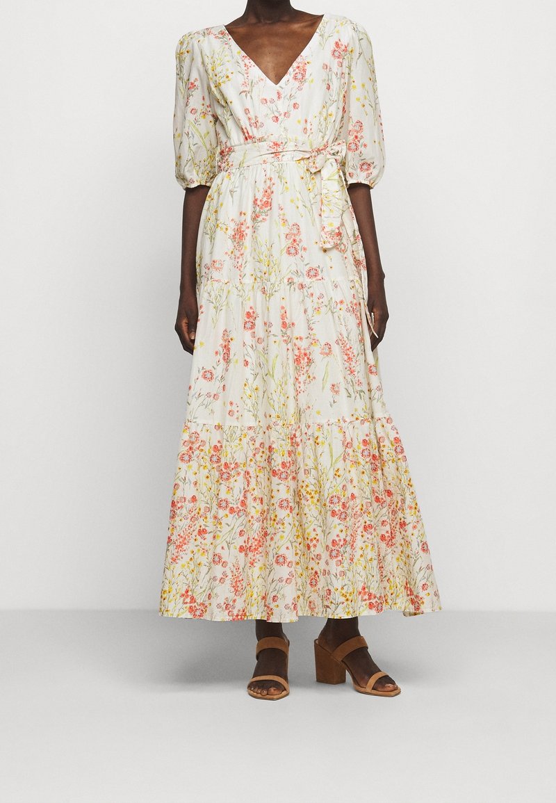 Maxiklänning i lätt tyg med blommönster i rosa och gult. Har en djup V-ringning och puffärmar, knytwaist och lagerfåll.