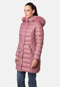 Abrigo acolchado rosa de plumas con capucha de pelo sintético, presenta un cierre frontal con cremallera, botones a presión y bolsillos laterales, mostrando una textura suave y brillante.