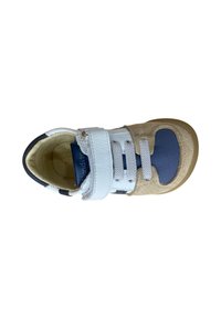 Zapato marrón claro y azul marino con texturas de cuero y ante, que presenta una cinta de Velcro blanca y cordones grises, puntera redondeada y suela de goma.