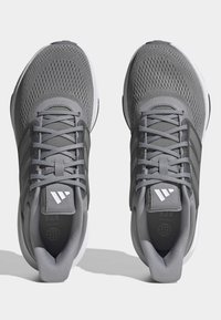 Scarpe da ginnastica grigie con tomaia in rete, design con lacci e suola in gomma. Presentano tre strisce grigie e il logo sulla linguetta.