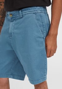 Lichtblauwe shorts van een katoenmix; voorzien van een knoopsluiting, elastische tailleband en zijzakken met een gladde textuur.