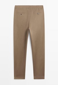 Brązowe spodnie zwężane wykonane z miękkiego materiału z elastycznym pasem, posiadające dwie tylne kieszenie i subtelne detale szwów.