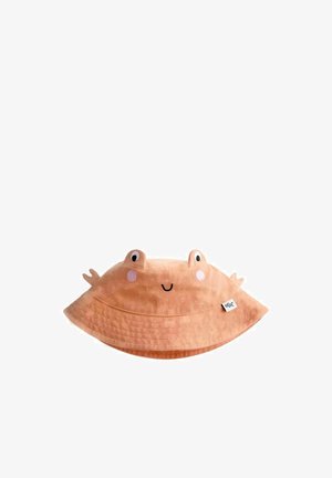 Pălărie tip bucket de culoare piersică, cu ochii unei broaște, obraji roșii, gură zâmbitoare și mici proeminențe în formă de coroană, pe un fundal alb.