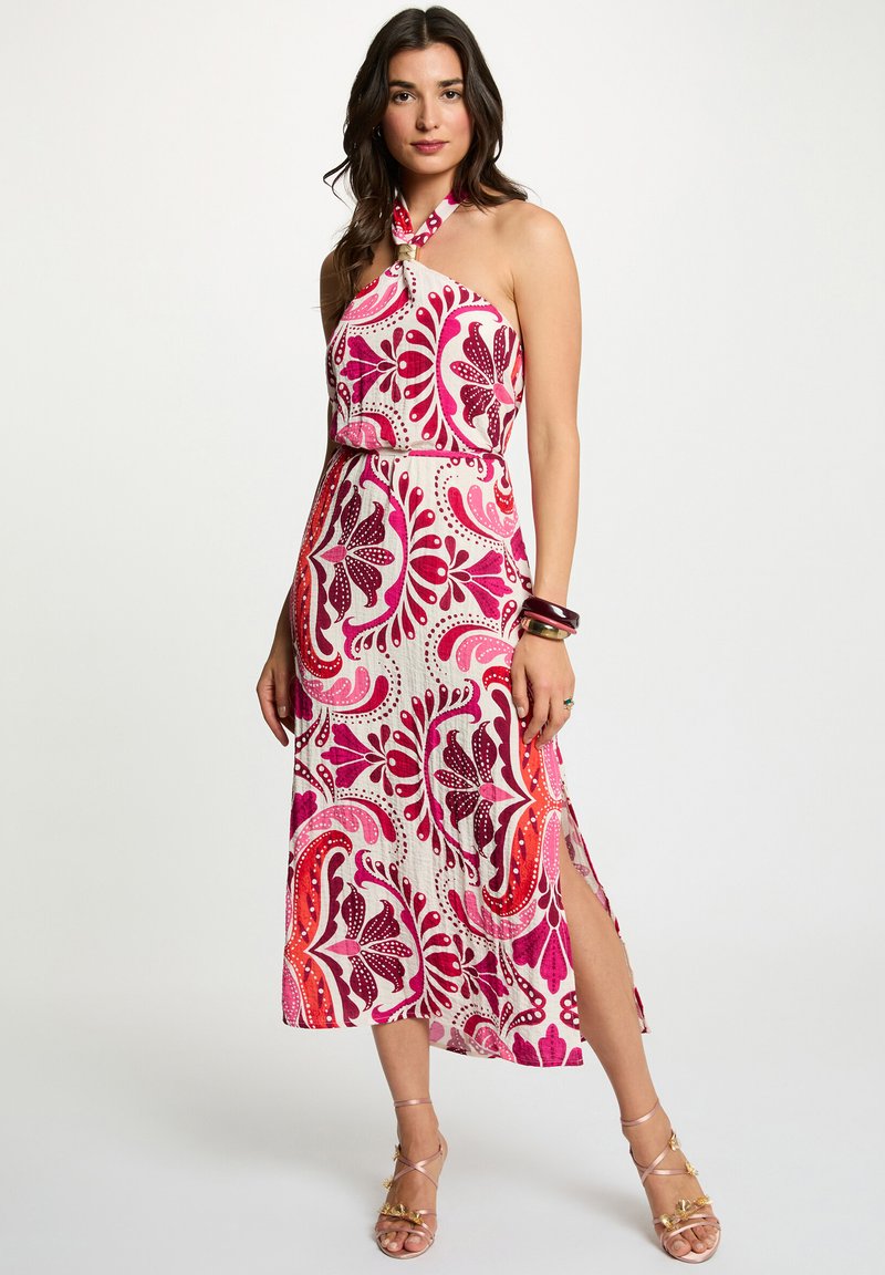 Robe blanche mi-longue au genou avec col halter, ornée de motifs floraux vibrants roses et rouges. Elle possède une fente avant et est fabriquée dans un tissu léger et texturé.