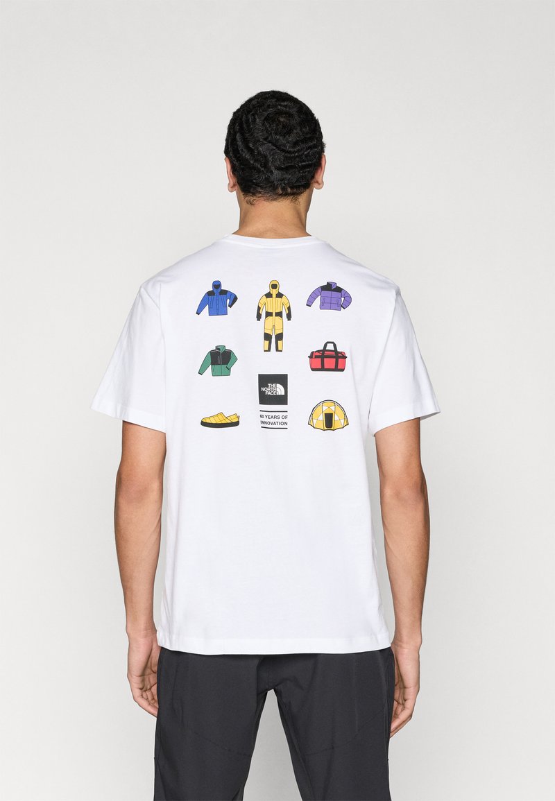 T-shirt blanc avec un design au dos représentant des vestes colorées, un sac, des chaussures et une tente, accompagné d'un logo indiquant "60 ans d'innovation".