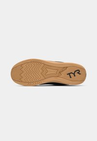 Black athletic shoe sole with a textured, zigzag rubber pattern. Features a light tan bottom and a black logo "TYR" near the heel.