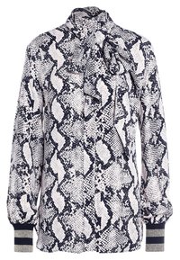 Blouse à manches longues avec imprimé serpent noir et blanc, col haut noué d’un nœud et poignets rayés en côte.