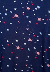 Granatowy materiał z rozproszonym wzorem wielokolorowych gwiazdek w odcieniach czerwonym, różowym, białym i niebieskim w różnych rozmiarach i stylach.