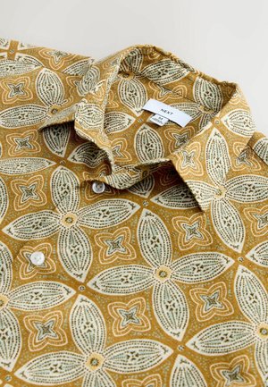 Kortærmet skjorte i sennepsgul med blomsterprint. Har krave og hvide knapper. Mærke placeret under kraven.