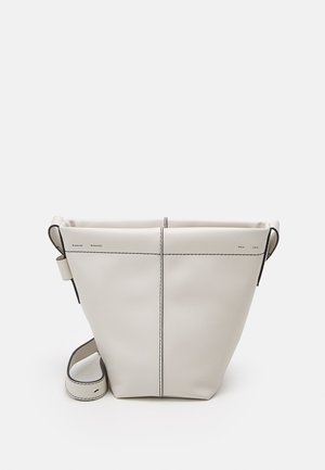 Minimalistische witte leren bucket bag met zwarte contrasterende stiksels en verstelbare schouderriem op een effen lichte achtergrond.