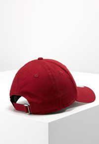 Piros pamut baseball sapka ívelt karimával, állítható pánttal a hátulján, és varrási részletekkel a napellenzőn. Strukturált szövet bevonat.