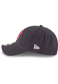 Mørkeblå baseballcaps med en rød brodert logo foran, kontrasterende hvite sømmer og en buet skygge. Har standard justerbar stropp.