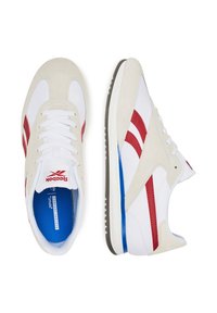 Tenisky Reebok z bielej kože a semišu, s červenými pruhmi a modrými akcentmi. S navliekacím dizajnom a textúrovanou podrážkou. Pohodlná stielka.