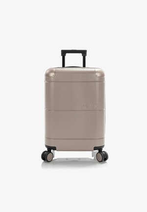 Silver hard-shell suitcase with a textured finish, extending handle, and four black wheels. The brand name "HEYS" is embossed on the front.