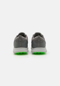 Gray athletic shoes with a textured upper, featuring a green rubber outsole and rear pull tab for easy wear. Suitable for active use.