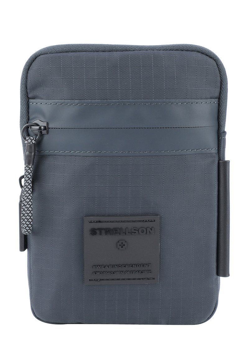 Donkergrijze textiel ritszak met een gladde afwerking, voorzien van een rubberen logo patch, getextureerde stof en een gepatternde ritsloper.