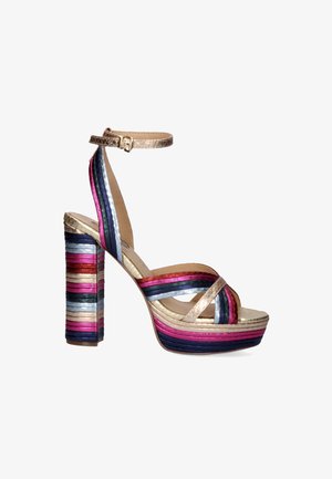 Sandalia de plataforma multicolor con una correa metálica dorada en el tobillo, con franjas horizontales en rosa, púrpura, azul y plata sobre un tacón grueso.