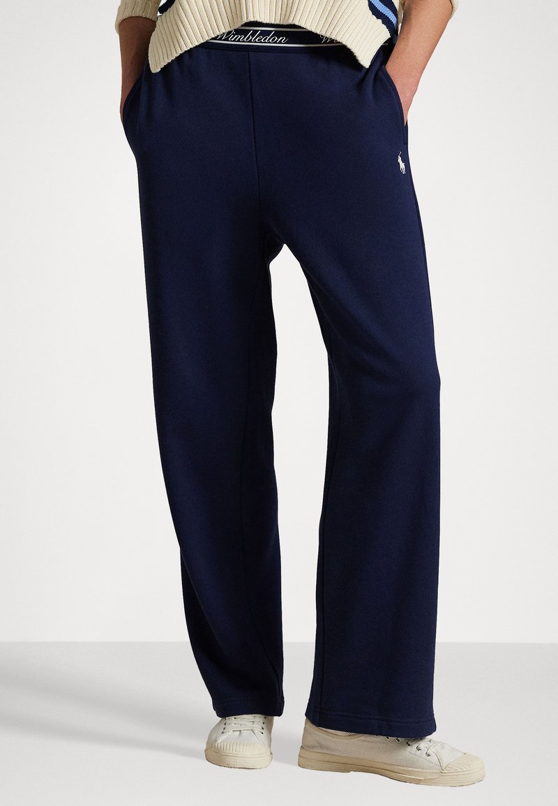 Marineblå sweatpants lavet af blødt stof med en afslappet pasform, der har sidelommer og logo detaljer på taljebåndet.