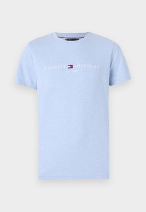 Helles blaues Baumwoll-T-Shirt mit kurzen Ärmeln. Auf der Brust in Weiß bedruckt mit "TOMMY HILFIGER" und "EST. 1985", mit Logo- Akzent.