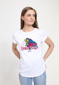 Bílá bavlněná tričko s barevným grafickým potiskem doktora Strange, s výrazným textem a složitými designovými prvky v zelené a růžové barvě.