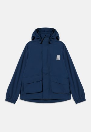Casaco azul-marinho com capuz, fecho de correr frontal, dois grandes bolsos com aba, punhos elásticos e um pequeno logótipo retangular no peito esquerdo.