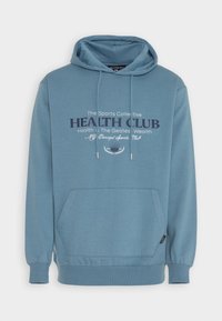 Felpa con cappuccio azzurro chiaro, tasca a marsupio, cappuccio con coulisse e testo stampato sul davanti. Tessuto in misto cotone con texture morbida.