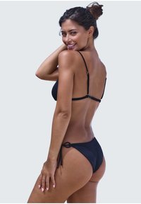 Black bikini with a textured surface, adjustable straps, and tie-side bottoms. Simple design focusing on function and fit.