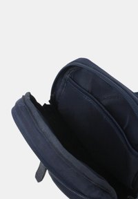 Bustina blu navy con cerniera aperta che mostra due scomparti principali con fodera in tessuto e divisorio interno.