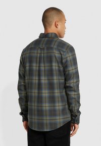Groene en blauwe geruite shirt, lange mouwen, knoopkraag, gebogen zoom, stoftextuur lijkt zacht, met een enkele rugplooien en label.