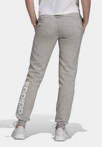 Grijze sweatpants met een taps toelopend ontwerp en duurzame boorden aan de enkels. Bevat een wit logo geprint langs het linkerpijp. Gemaakt van zachte, gestructureerde stof.